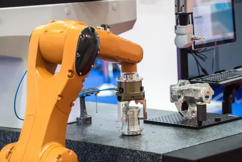 bras robotisé saisissant une pièce métallique