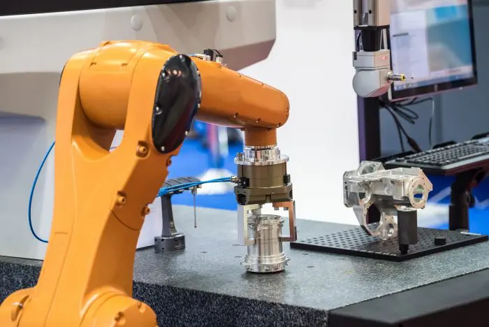 bras robotisé saisissant une pièce métallique
