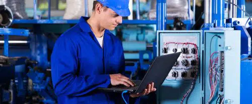 technicien devant un ordinateur et une armoire de système automatisé