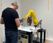 stagiaire en formation devant robot fanuc