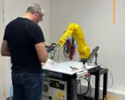 stagiaire en formation devant robot fanuc