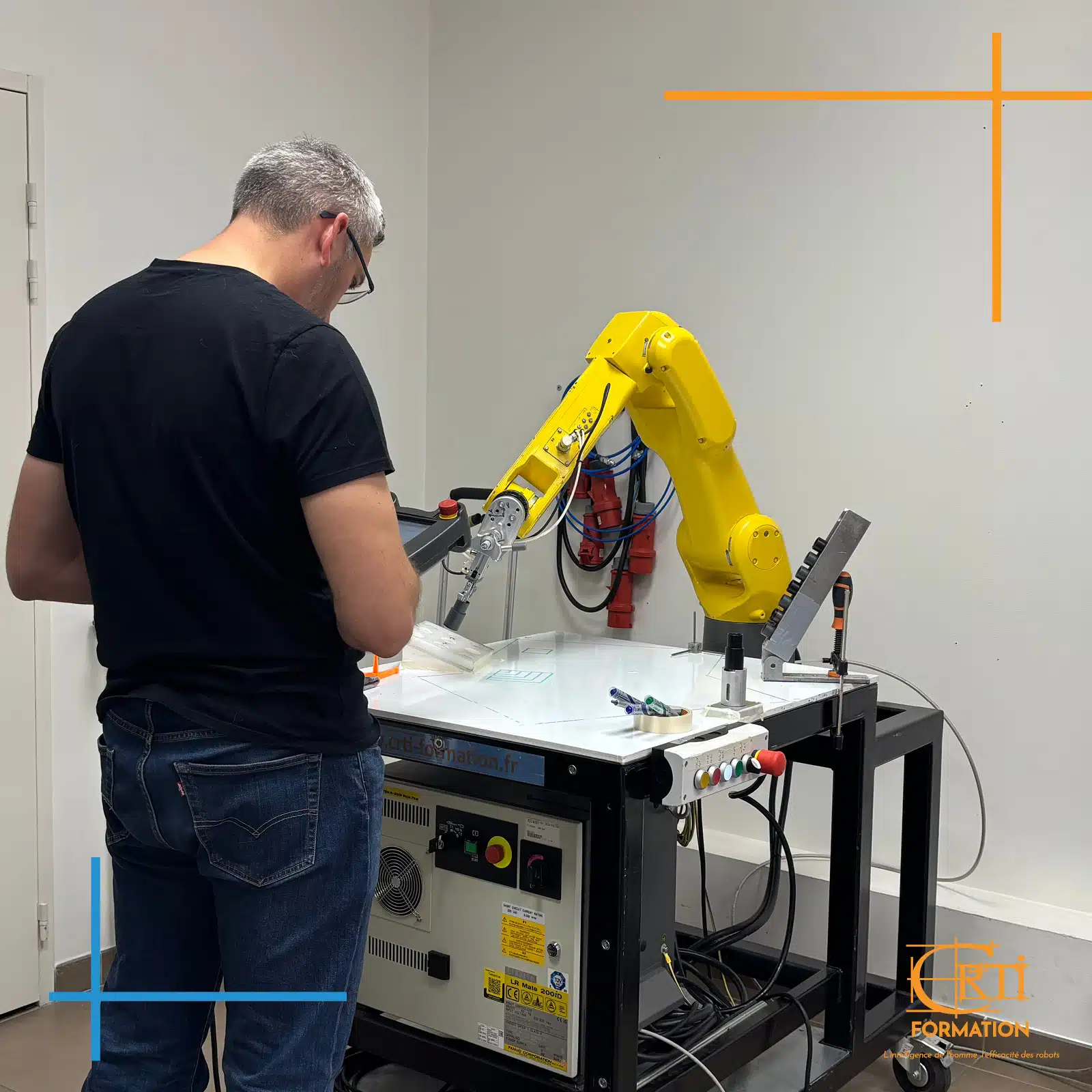 stagiaire en formation devant robot fanuc
